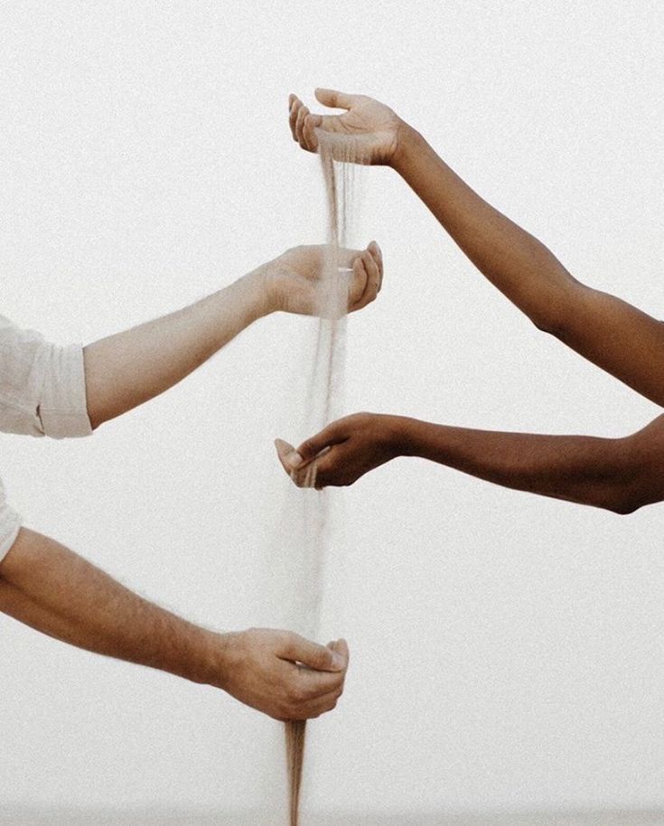 Mani diverse sostengono insieme un tessuto leggero